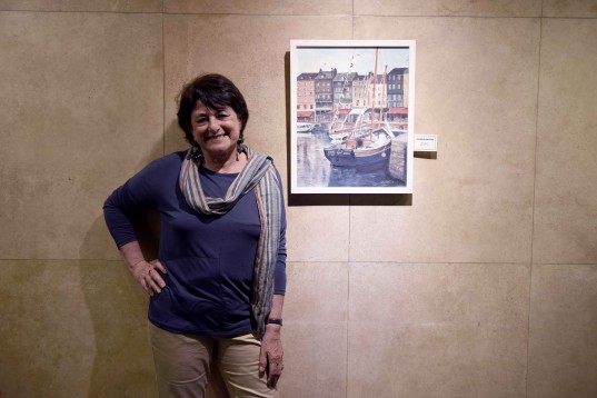 Gloria Gattás sonríe junto a su obra: "Honfleur", óleo sobre tela.